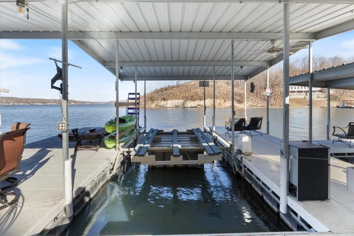 This image features a dock with kayaks and a seating area right at the water’s edge. The setting is tranquil, with calm waters inviting guests to relax, fish, or launch a kayak adventure. Subtle sunset lighting hints at the potential for memorable evenings outdoors.