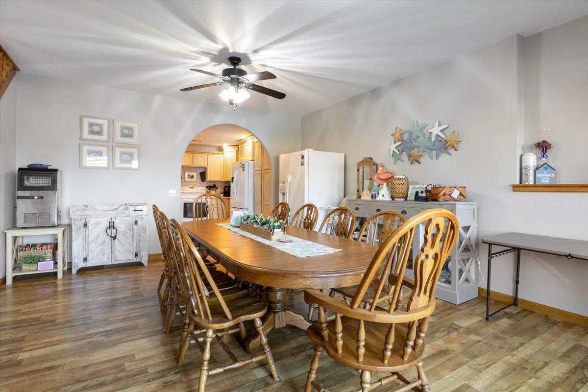 A large dining table sits near the kitchen, accented with decorative starfish and appliances in the background, suggesting a seamless flow between meal preparation and communal dining. The inviting setup is ideal for family dinners or festive gatherings.